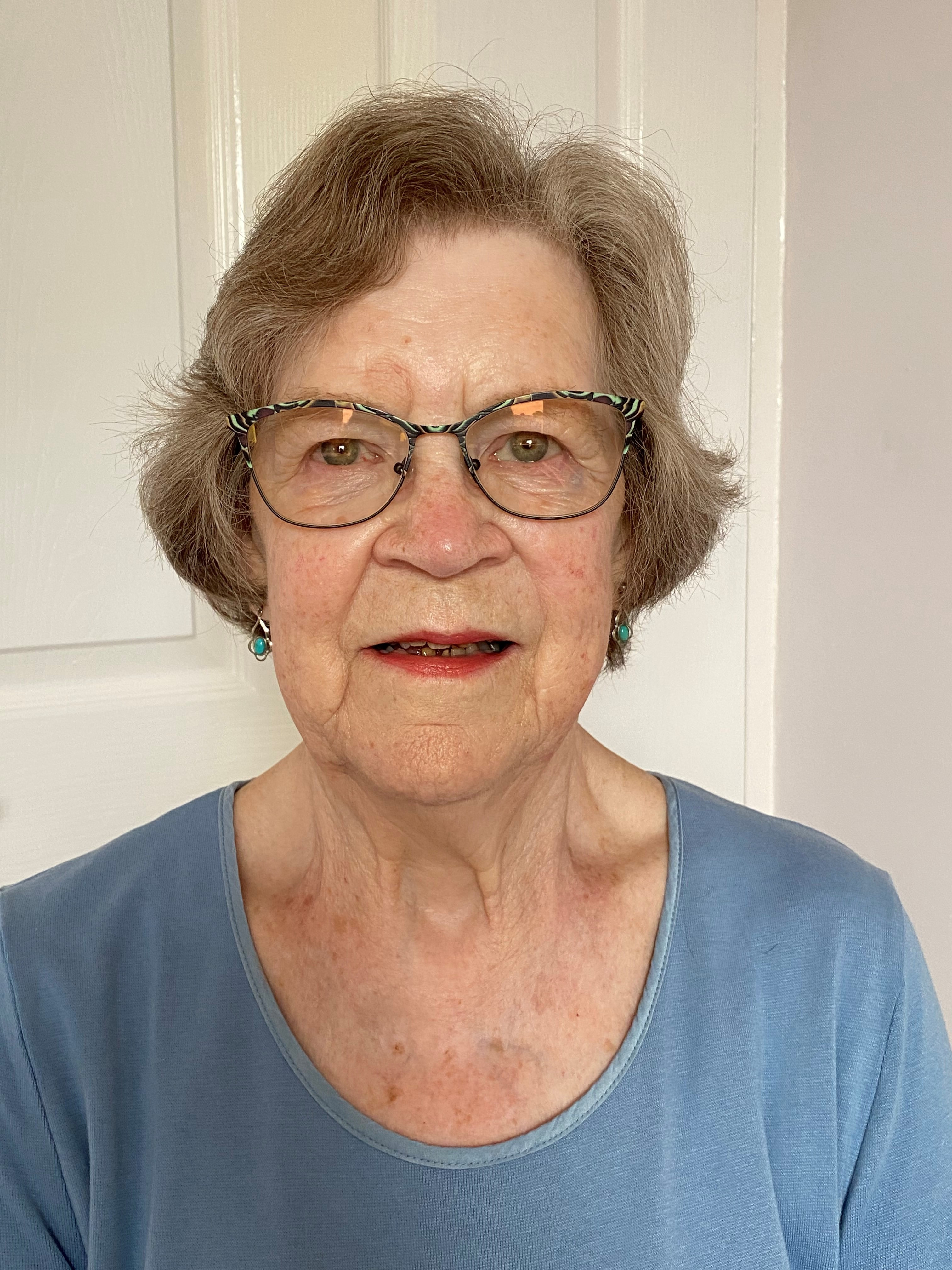 Head and shoulders of Benita Beales, she is wearing a blue top and glasses