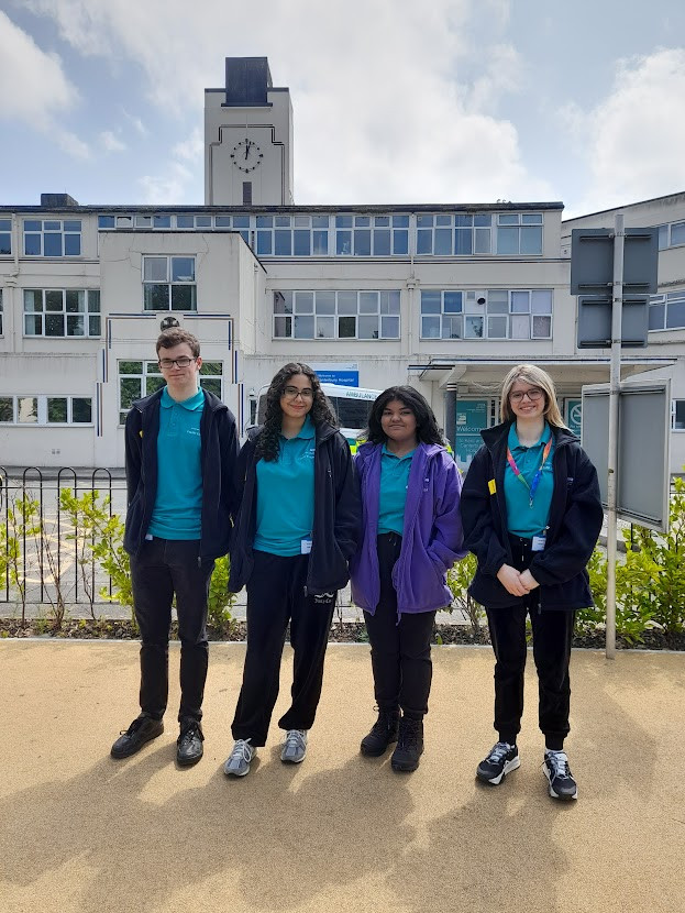 Callum Howes, Habeeba Waleed, Aishwarya Suganthi and India Goodey. They are pictured in the garden outside the Kent and Canterbury Hospital, wearing blue youth volunteer t-shirts