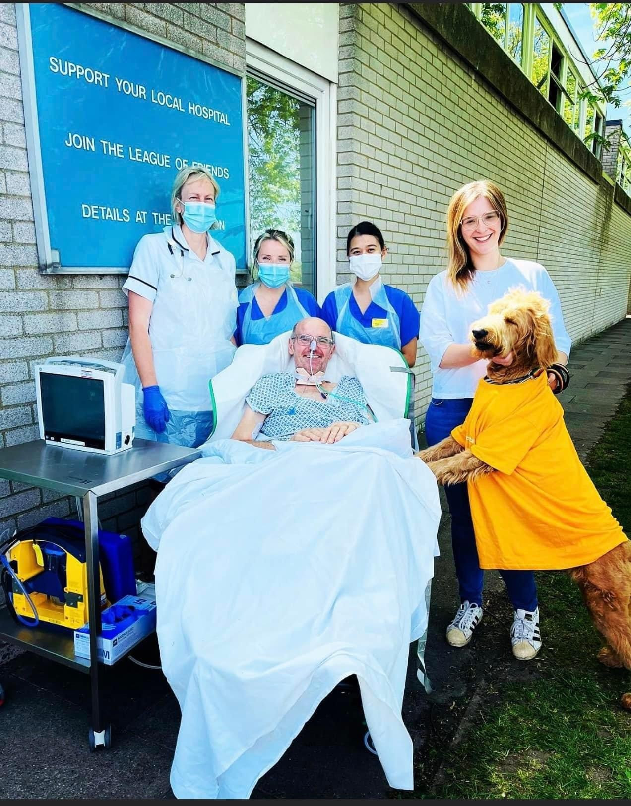 Kayleigh and Martha the dog with her dad on one of their visits while he was in hospital. Hospital staff also pictured.