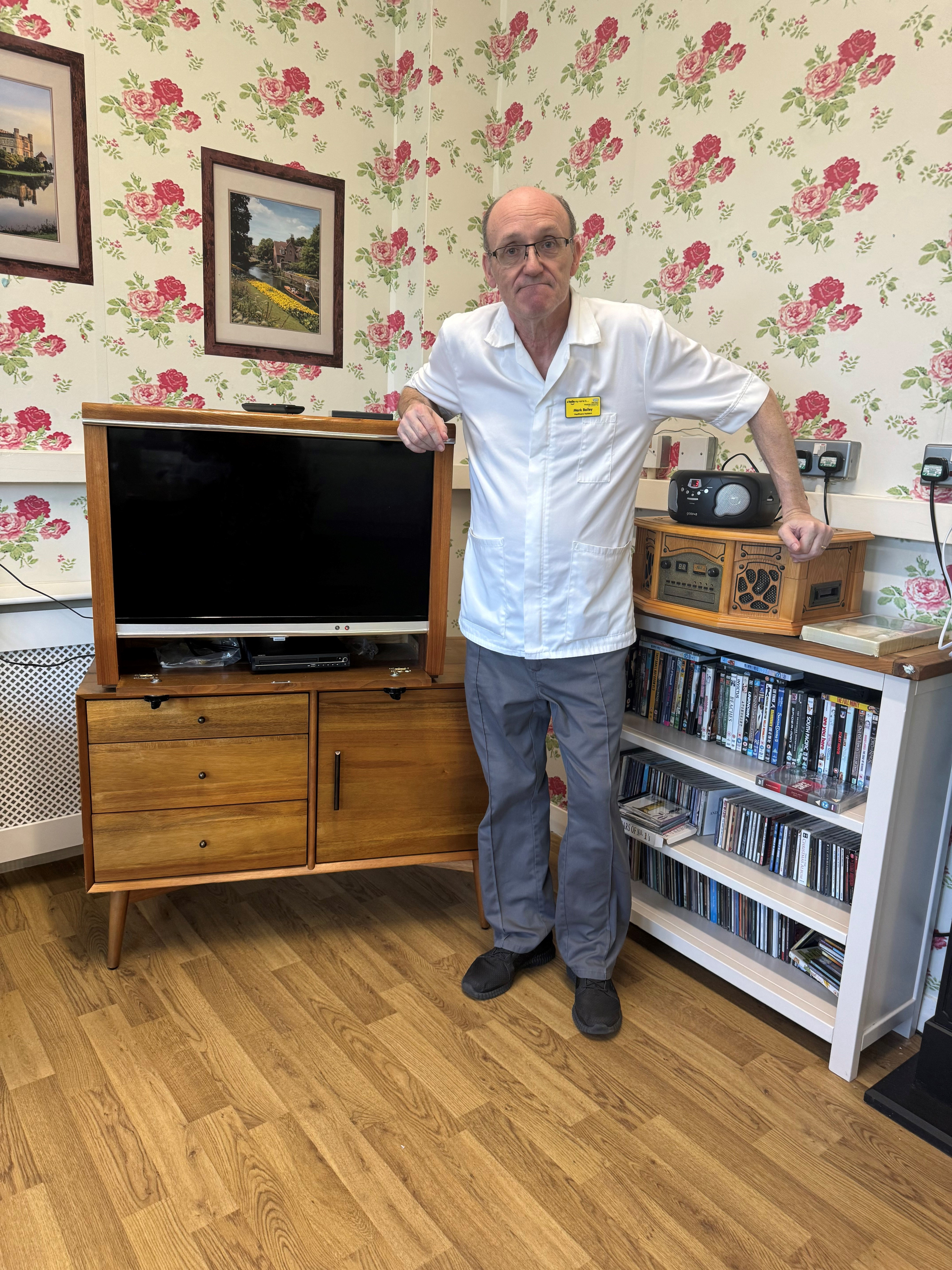 Mark Bailey in the day room, which is decorated in an old-fashioned style