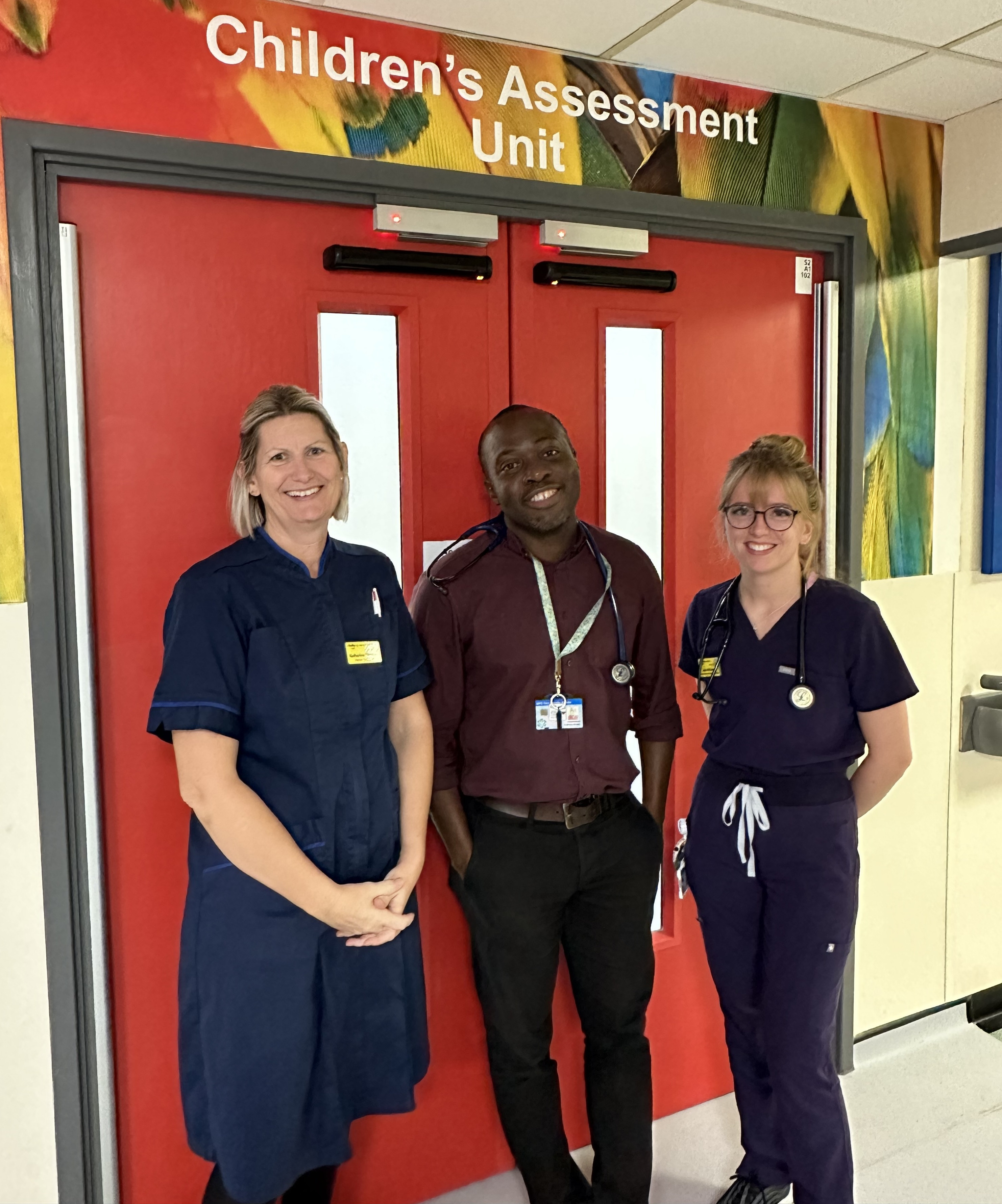 Katherine Forwood, Dr Amadi and Jess McSwiney outside the doors of the children's assessment unit