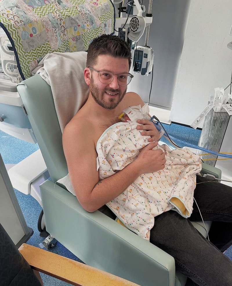 Matthew cuddling baby Kai in the NICU.