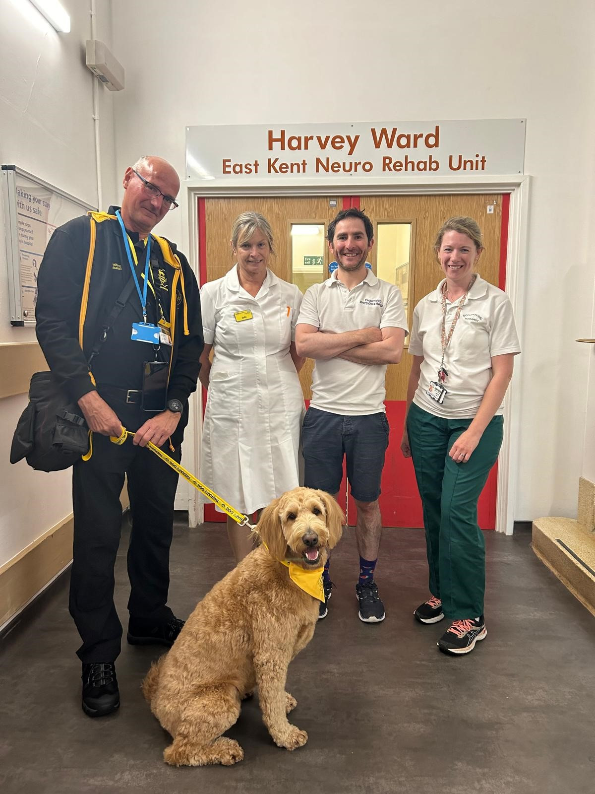 Nigel and Martha the dog with some of the team from Harvey ward where he was a patient
