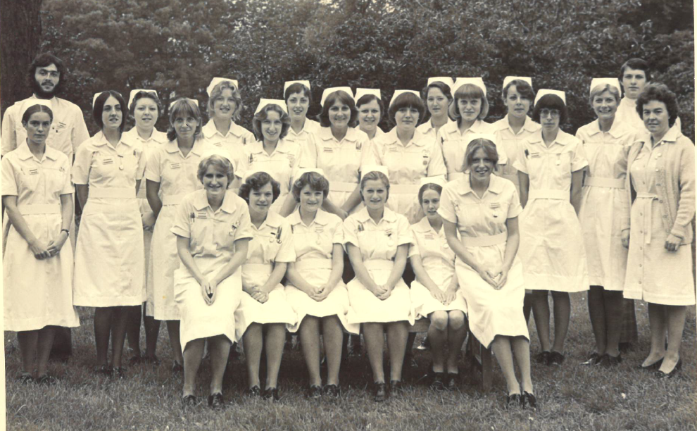 Keith with his fellow student nurses in 1977. Black and white image of a group of largely female nurses with two men, one at each end
