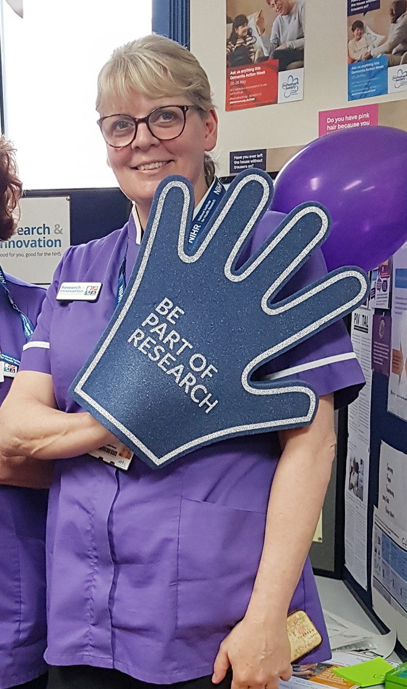 Ruth Hulbert wearing a 'be part of research' foam hand