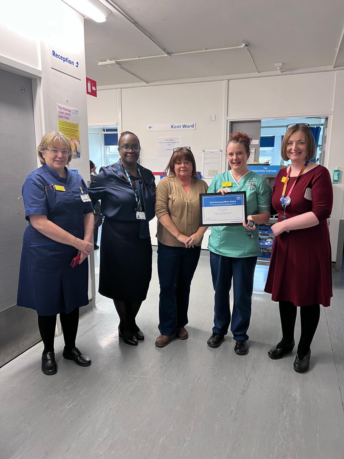 Sarah Hayes, right, presenting the award to Helen Garlinge, watched by colleagues