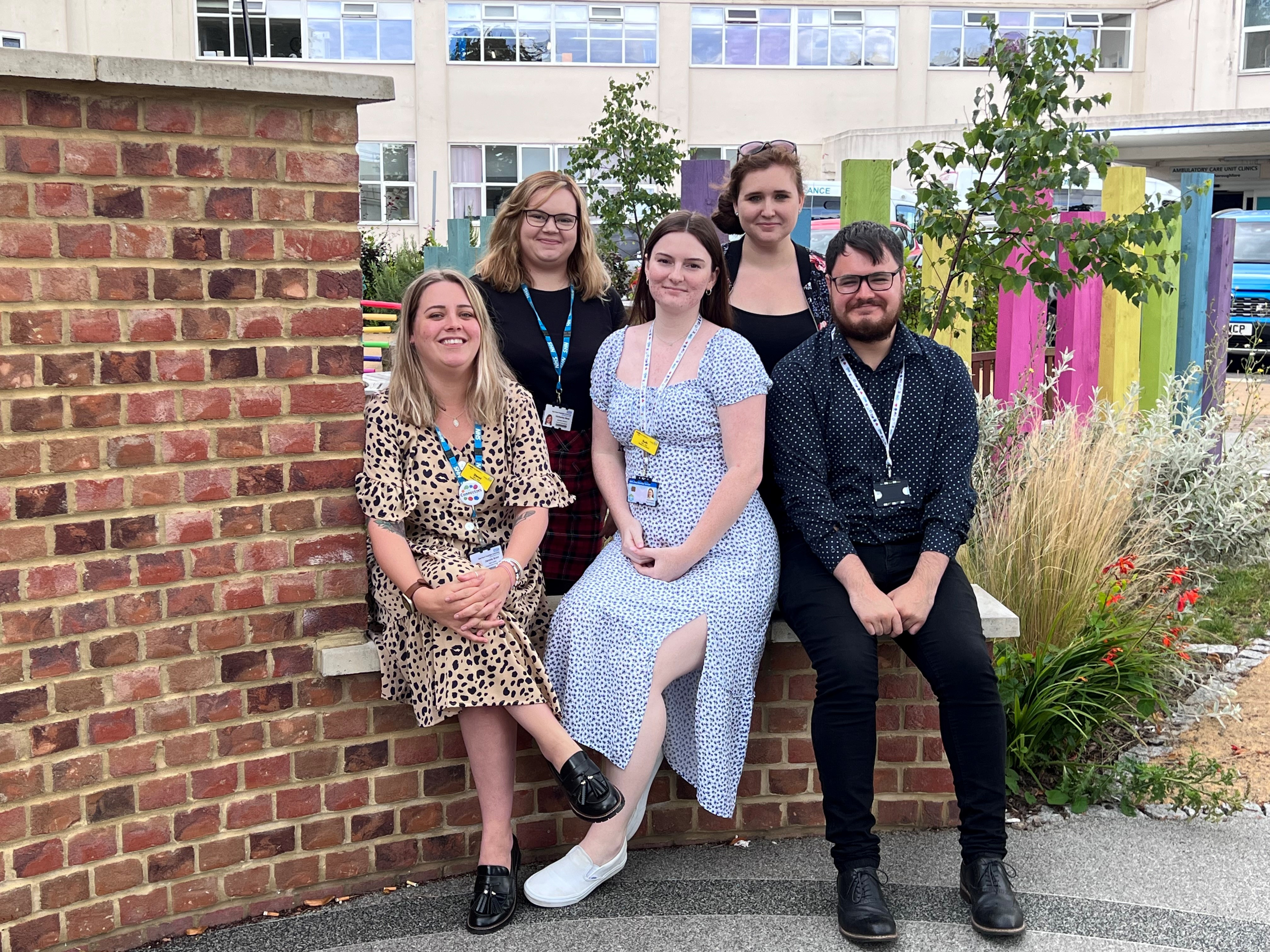 The team who will take on the million steps challenge. Image shows five people in a garden area, three are sitting on a low wall